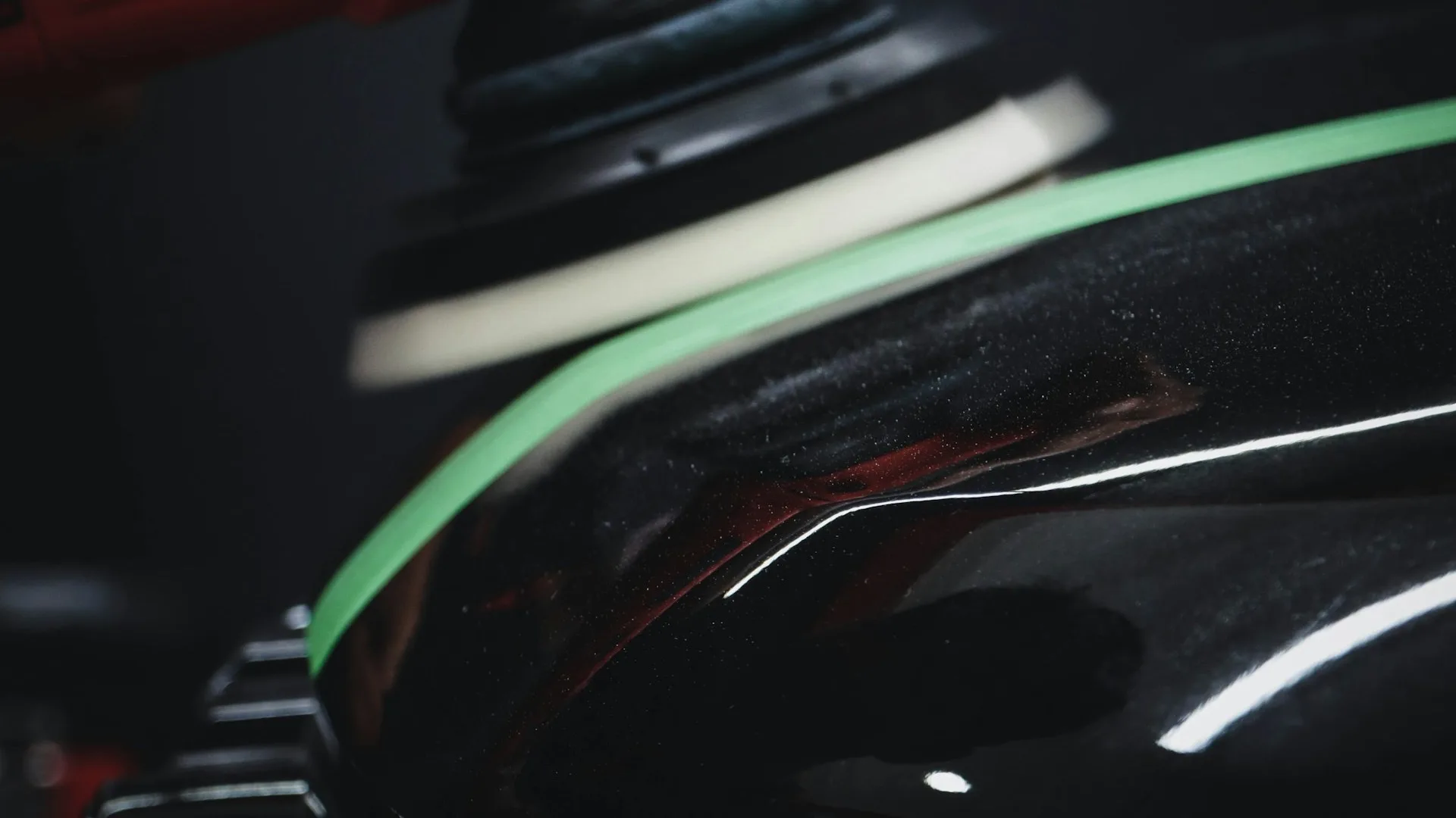Dual-action polisher working a black panel during paint correction